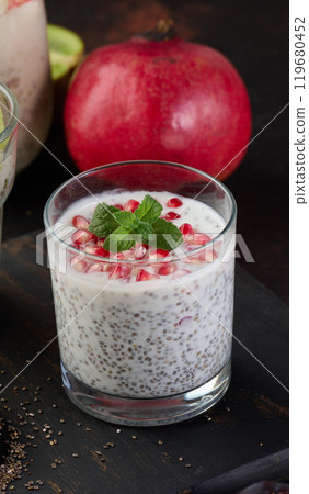 Glass of chia seeds and yogurt with pomegranate on table 119680452