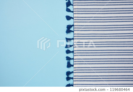 Folded linen striped kitchen towel on blue background, top view Folded linen striped kitchen towel on blue background, top view 119680464