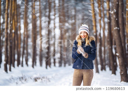 Happy woman plays with snow in sunny winter day. Girl enjoys winter, frosty day. Playing with snow. Happy woman plays with snow in sunny winter day. Girl enjoys winter, frosty day. Playing with snow. 119680613