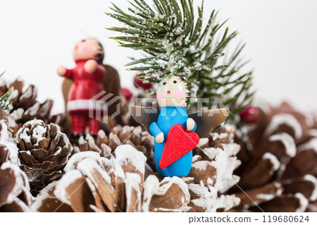Christmas ornament featuring a small wooden angel holding a red heart 119680624