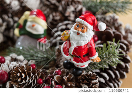 A small figurine of Santa Claus in a red and white suit holding a green sack, 119680741