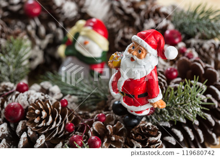 A small figurine of Santa Claus in a red and white suit holding a green sack, A small figurine of Santa Claus in a red and white suit holding a green sack, 119680742