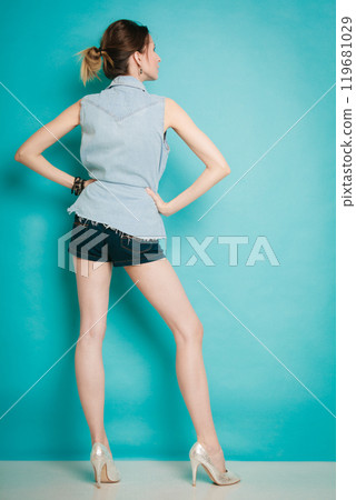 Summer fashion girl in jeans shirt shorts and high heels. Summer fashion girl in jeans shirt shorts and high heels. 119681029