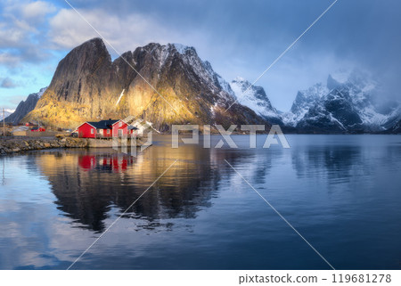 Red rorbuer and snowy rocks lighted by sun, blue sea at sunset 119681278