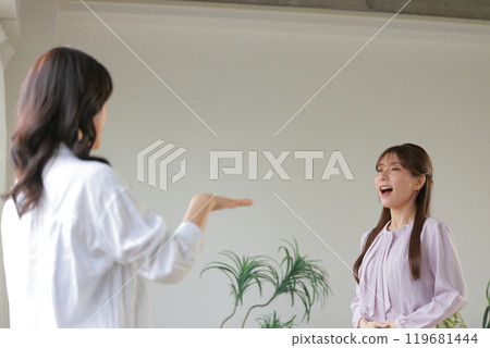 Young woman receiving voice training and instructor_1 119681444