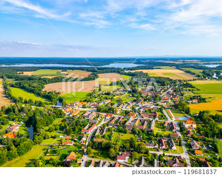 Expansive aerial view showcasing the rural landscape around Trebon, Czechia, featuring lush fields, serene water bodies, and quaint villages nestled within greenery under a clear blue sky. Expansive aerial view showcasing the rural landscape around Trebon, Czechia, featuring lush fields, serene water bodies, and quaint villages nestled within greenery under a clear blue sky. 119681837