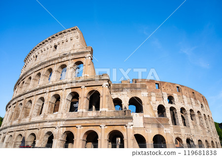 Visitors admire the majestic Colosseum in Rome, Italy, marveling at its ancient architecture against a clear blue sky, showcasing the grandeur of this historic landmark. Visitors admire the majestic Colosseum in Rome, Italy, marveling at its ancient architecture against a clear blue sky, showcasing the grandeur of this historic landmark. 119681838