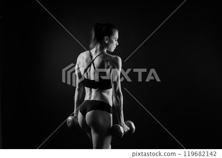 Fitness, workout and woman with weights in a studio for a arm or strength training with motivation. Fitness, workout and woman with weights in a studio for a arm or strength training with motivation. 119682142