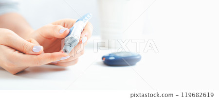 Woman is holding a glucometer Woman is holding a glucometer 119682619