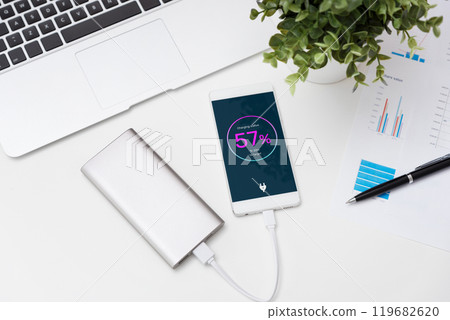 Phone is charging, power bank on desk Phone is charging, power bank on desk 119682620