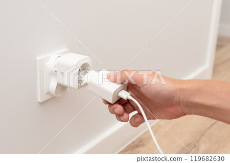 Man plug charger into smart socket 119682630