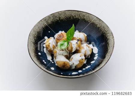 Baked baby potatoes drizzled with creamy sauce and garnished with fresh basil for side dish Baked baby potatoes drizzled with creamy sauce and garnished with fresh basil for side dish 119682683