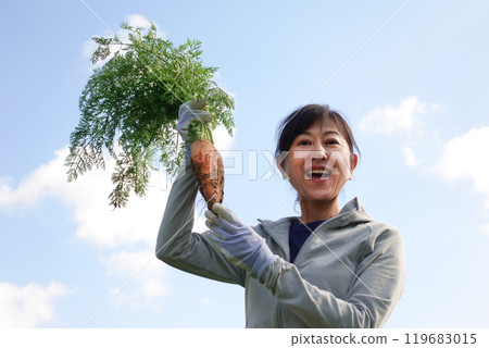 拿著收穫的胡蘿蔔的中年婦女 119683015