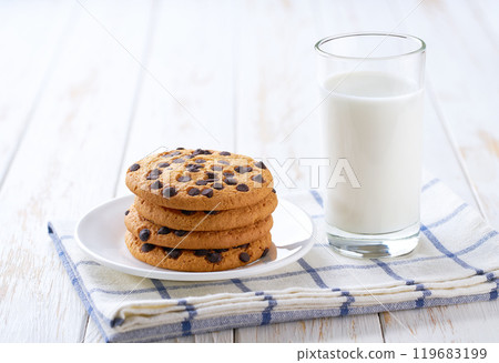 Chocolate chip cookies and milk on a white table, close up. Chocolate chip cookies and milk on a white table, close up. 119683199
