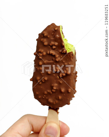 A man holding a green tea ice cream bar coated in chocolate with a bite taken out. A man holding a green tea ice cream bar coated in chocolate with a bite taken out. 119683251