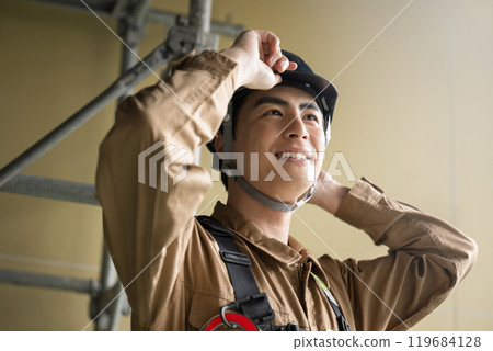 戴著頭盔的現場工作人員抬頭的特寫 119684128