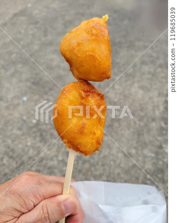 Hands eating potato tempura Hands eating potato tempura 119685039