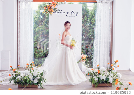 Small wedding - the priest is present, the bride and groom hold their wedding bouquets, hold hands, and share a beautiful moment with family and friends. 119685953