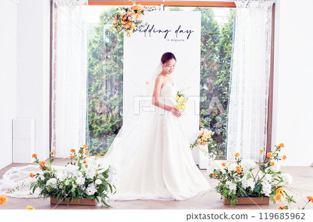 Small wedding - the priest is present, the bride and groom hold their wedding bouquets, hold hands, and share a beautiful moment with family and friends. Small wedding - the priest is present, the bride and groom hold their wedding bouquets, hold hands, and share a beautiful moment with family and friends. 119685962