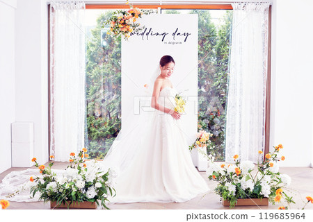 Small wedding - the priest is present, the bride and groom hold their wedding bouquets, hold hands, and share a beautiful moment with family and friends. 119685964