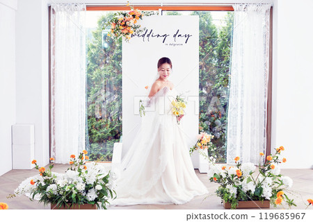 Small wedding - the priest is present, the bride and groom hold their wedding bouquets, hold hands, and share a beautiful moment with family and friends. Small wedding - the priest is present, the bride and groom hold their wedding bouquets, hold hands, and share a beautiful moment with family and friends. 119685967