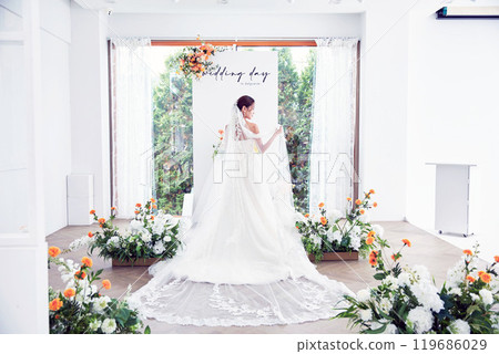 Small wedding - the priest is present, the bride and groom hold their wedding bouquets, hold hands, and share a beautiful moment with family and friends. 119686029