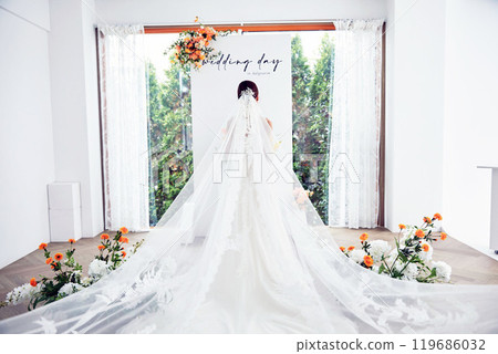 Small wedding - the priest is present, the bride and groom hold their wedding bouquets, hold hands, and share a beautiful moment with family and friends. 119686032