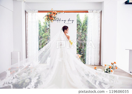 Small wedding - the priest is present, the bride and groom hold their wedding bouquets, hold hands, and share a beautiful moment with family and friends. Small wedding - the priest is present, the bride and groom hold their wedding bouquets, hold hands, and share a beautiful moment with family and friends. 119686035