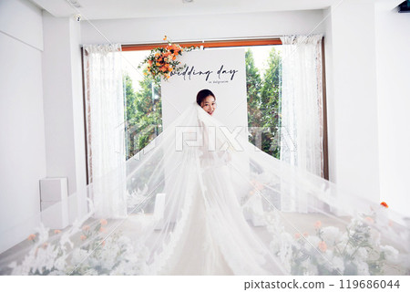 Small wedding - the priest is present, the bride and groom hold their wedding bouquets, hold hands, and share a beautiful moment with family and friends. 119686044