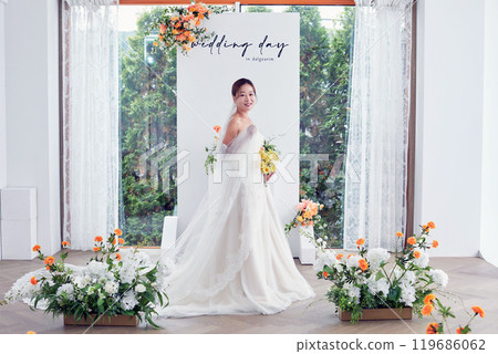 Small wedding - the priest is present, the bride and groom hold their wedding bouquets, hold hands, and share a beautiful moment with family and friends. 119686062