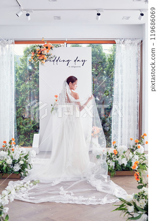 Small wedding - the priest is present, the bride and groom hold their wedding bouquets, hold hands, and share a beautiful moment with family and friends. Small wedding - the priest is present, the bride and groom hold their wedding bouquets, hold hands, and share a beautiful moment with family and friends. 119686069