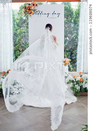 Small wedding - the priest is present, the bride and groom hold their wedding bouquets, hold hands, and share a beautiful moment with family and friends. 119686074