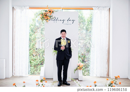 Small wedding - the priest is present, the bride and groom hold their wedding bouquets, hold hands, and share a beautiful moment with family and friends. Small wedding - the priest is present, the bride and groom hold their wedding bouquets, hold hands, and share a beautiful moment with family and friends. 119686158