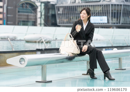 年輕女商人在市中心喝外帶咖啡放鬆 119686170