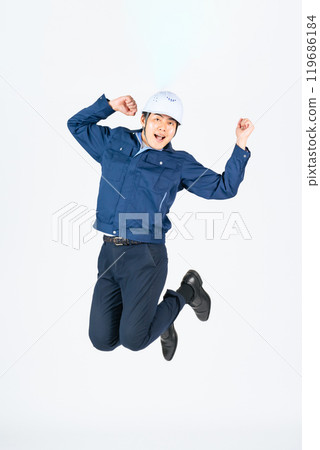 Full-body photo of a male worker jumping 119686184