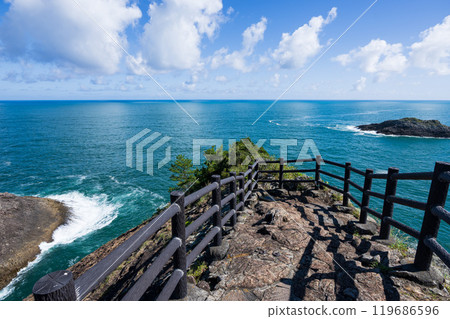 A spectacular view from the promenade at Hyuga Misaki Observatory. Blue sky and blue sea on the coast. White clouds reflected in the sea. 119686596