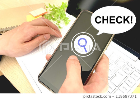 The hands of a person checking their smartphone 119687371