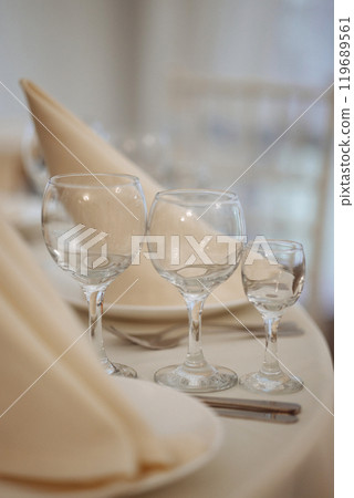 A table with a white tablecloth and a napkin folded in a triangle. Wedding table setting. A table with a white tablecloth and a napkin folded in a triangle. Wedding table setting. 119689561