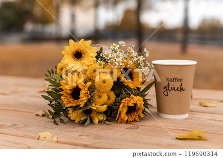 Bouquet of sunflowers and yellow flowers. Autumn bouquet on wooden table outside Bouquet of sunflowers and yellow flowers. Autumn bouquet on wooden table outside 119690314