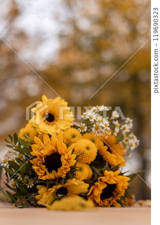 Bouquet of sunflowers and yellow flowers. Autumn bouquet on wooden table outside Bouquet of sunflowers and yellow flowers. Autumn bouquet on wooden table outside 119690323