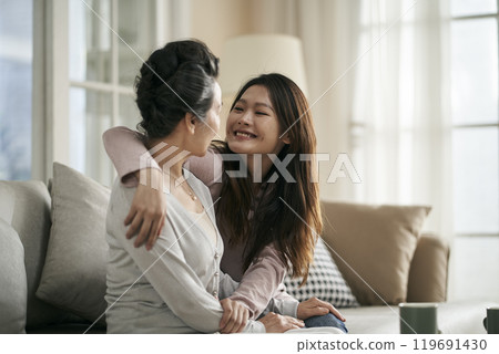 asian adult daughter and senior mother chatting at home 119691430