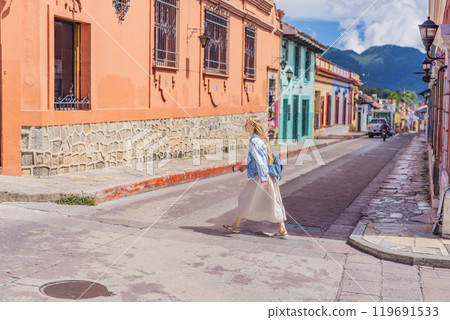 Female tourist walks through the colonial streets San Cristobal de las Casas, Mexico. Cultural exploration, architecture, and travel experience concept Female tourist walks through the colonial streets San Cristobal de las Casas, Mexico. Cultural exploration, architecture, and travel experience concept 119691533