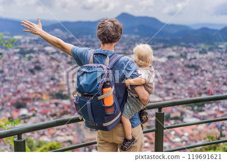 Dad and his baby son tourists in front of the panoramic view of Orizaba from Cerro del Borrego, Mexico. Travel, scenic landscape, and adventure concept Dad and his baby son tourists in front of the panoramic view of Orizaba from Cerro del Borrego, Mexico. Travel, scenic landscape, and adventure concept 119691621