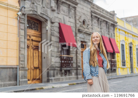 Female tourist walking through the colorful colonial streets of Puebla, Mexico. Travel, cultural exploration, and vibrant architecture concept 119691766