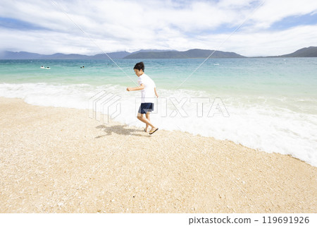 一個男孩在美麗的大海裡玩耍 119691926