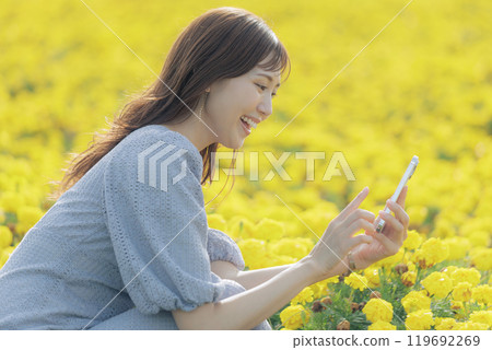 Woman taking a flower with a smartphone 119692269