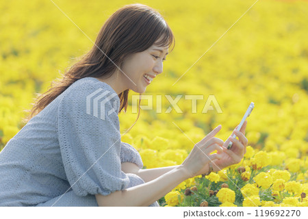 Woman taking a flower with a smartphone 119692270