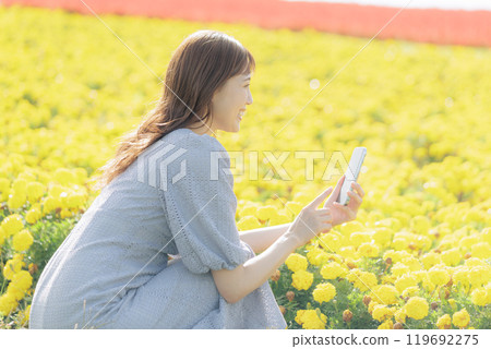 Woman taking a flower with a smartphone 119692275