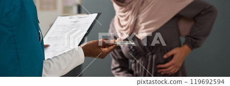 Holding Clipboard and Pen While Discussing With Muslim Patient 119692594