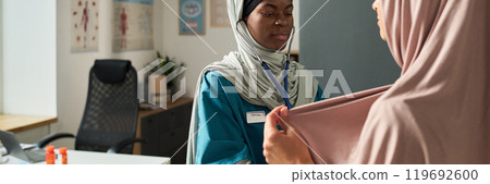Muslim Nurse Providing Patient Care in Medical Office Setting 119692600